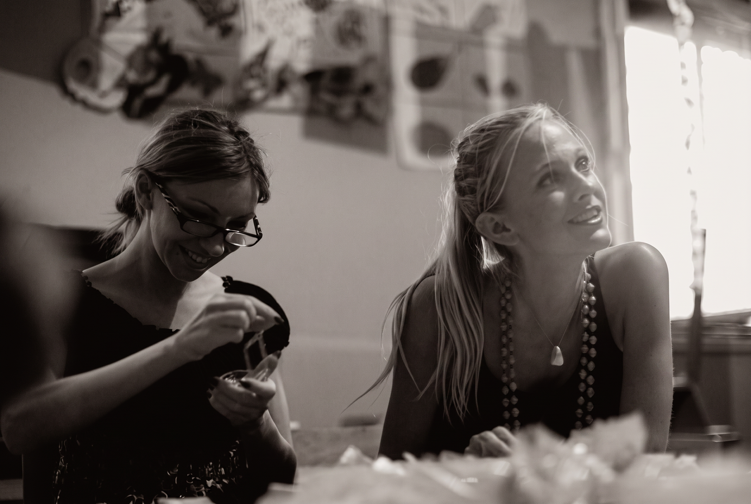 Andrea and a friend laughing candidly at a table