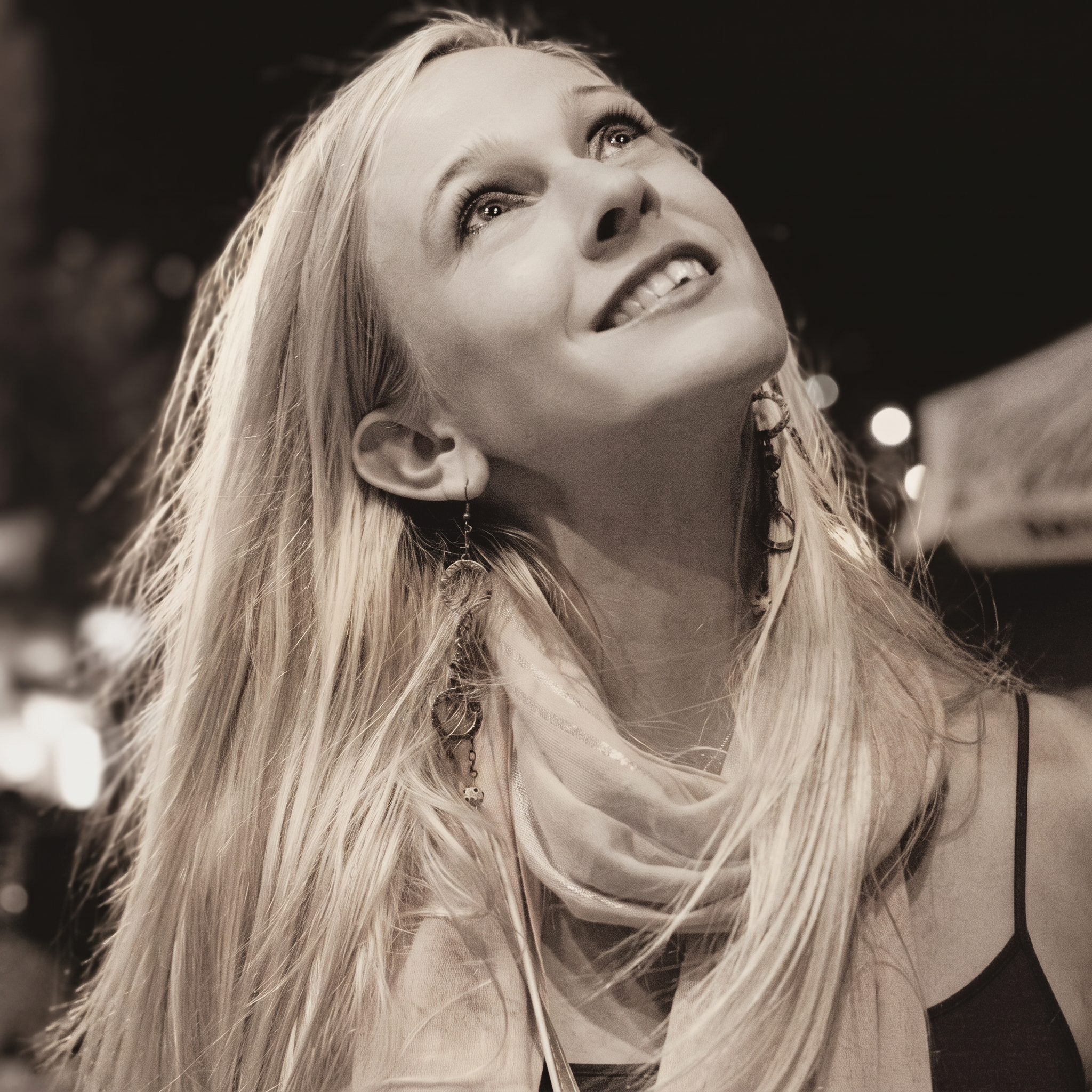 Andrea looking upward, laughing with joy under evening light