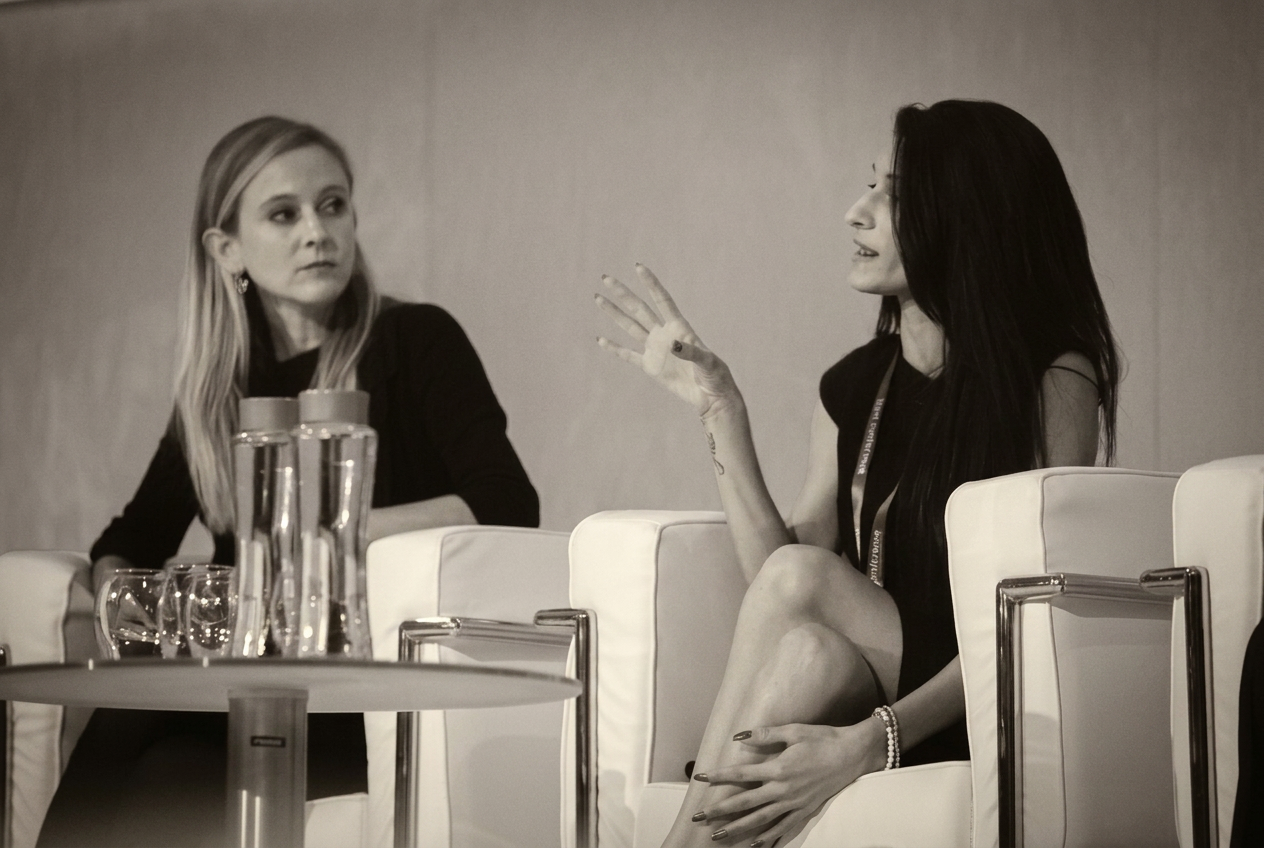 Andrea speaking on a panel, engaged mid-gesture